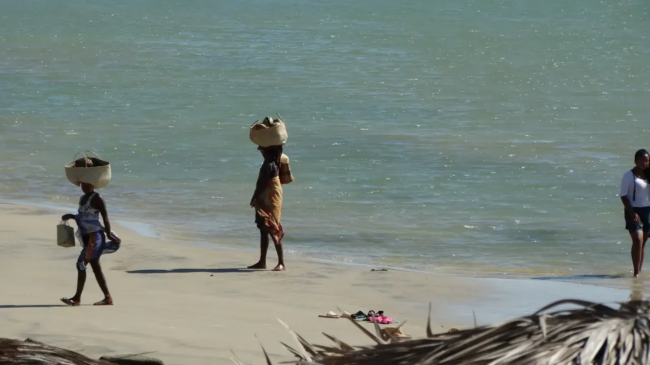 Figurei camminano sulla spiaggia di Morondava in Madagascar con la vista sull'oceano.