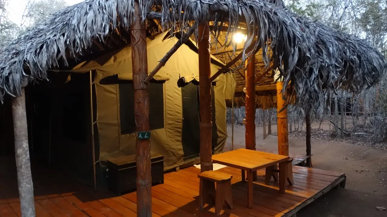 Una tenda con tetto di paglia e tavolo in una struttura rurale a Madagascar.