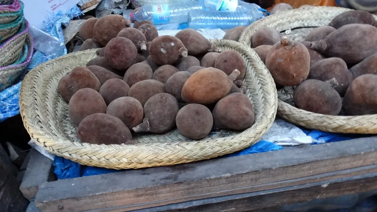 Frutta di baobab in una cesta all'aperto.