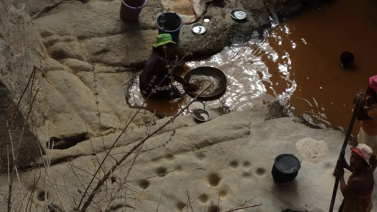 Un fiume fangoso scorre attraverso un paesaggio roccioso in Madagascar.