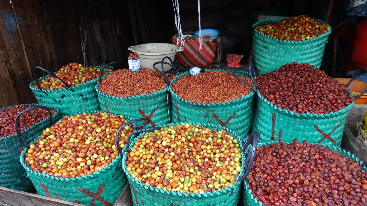 Mercato di Antsirabe-Sobotsy con frutta esposta in ceste verdi.