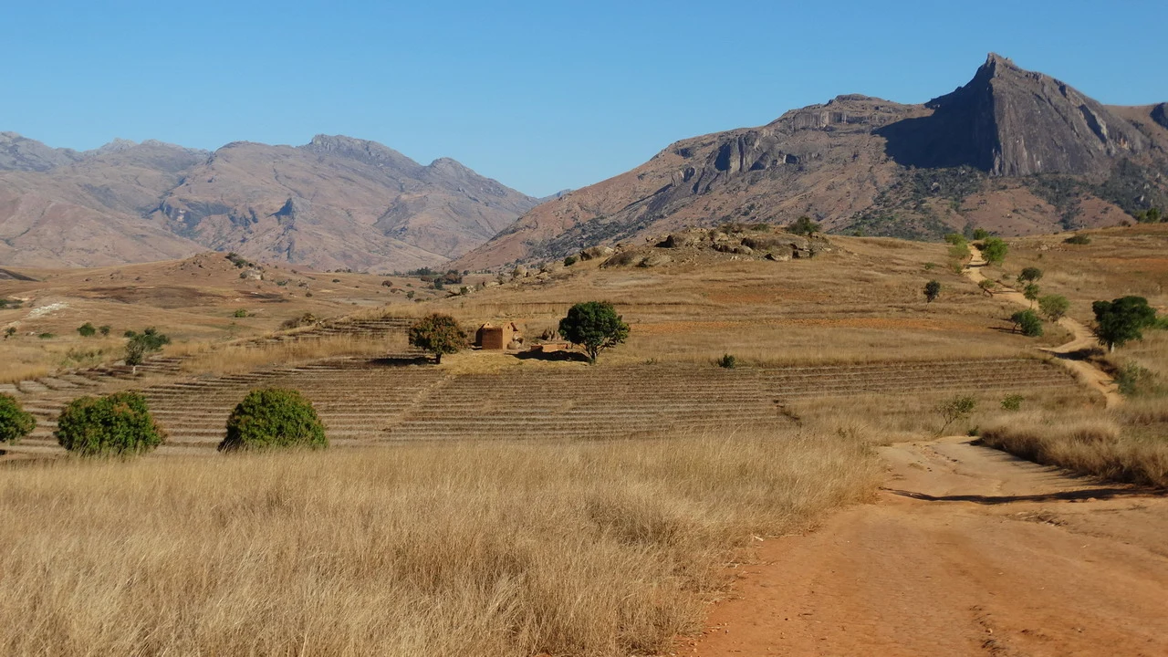 Arido paesaggio collinare della Madagascar con montagne in lontananza.