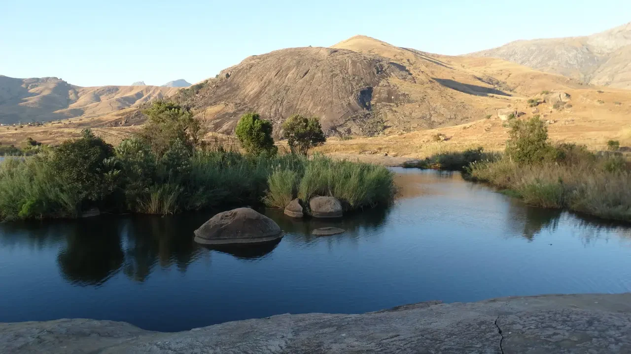 Un fiume scorre attraverso un paesaggio collinare secco e arido.