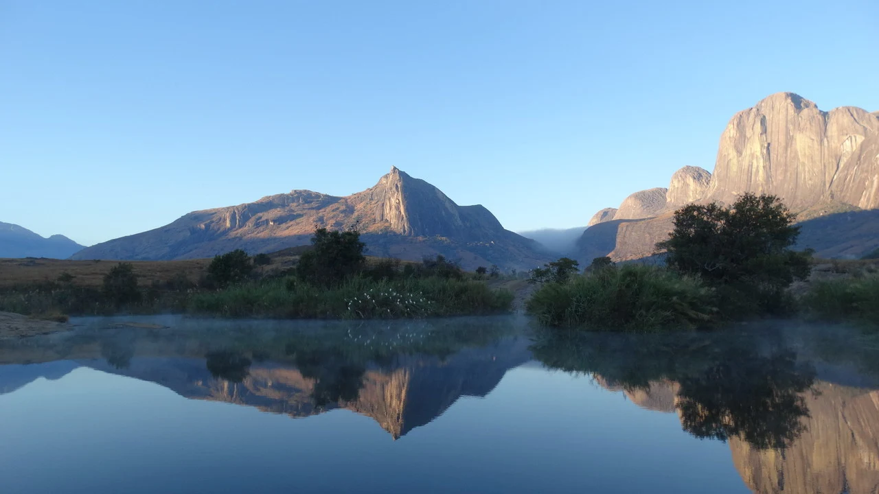 Riflesso delle montagne rocciose sull'acqua calma.