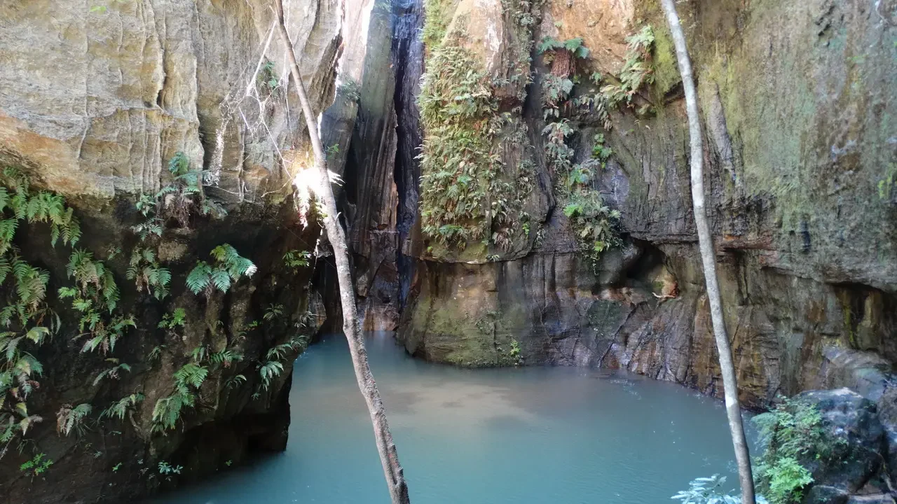 Cascata nella gola di Isalo-N.P. con vegetazione lussureggiante e acqua turchese.
