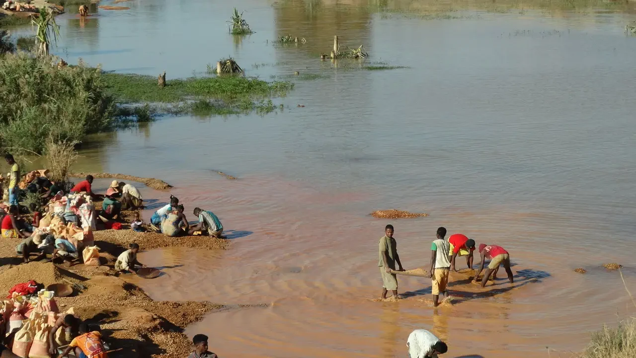 Persone si immergono in un fiume fangoso durante una passeggiata tra Isalo e Toliara a Madagascar.