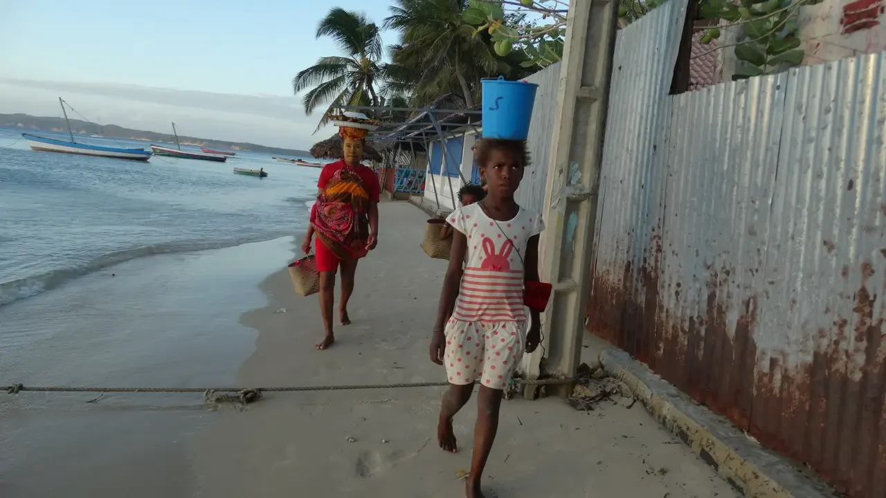 Due bambini camminano lungo la spiaggia di una località malgachesi all'alba.