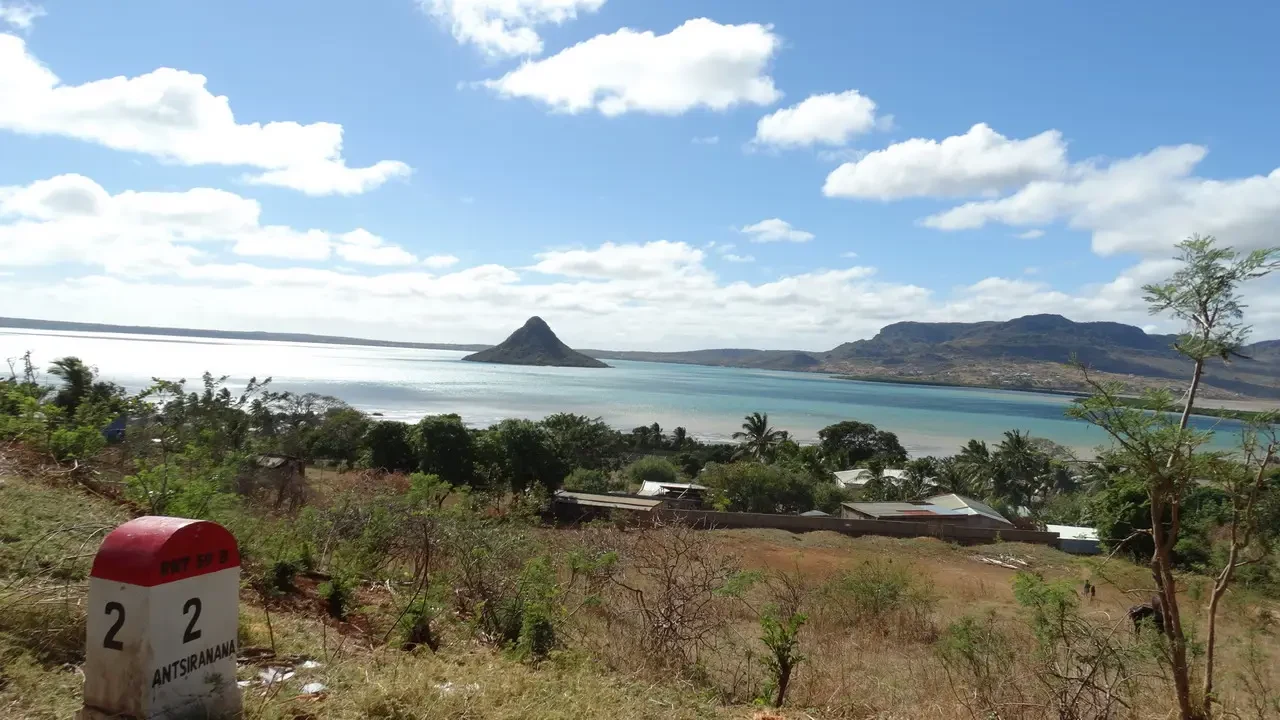 Paesaggio costiero di Madagascar con una penisola rocciosa in lontananza.