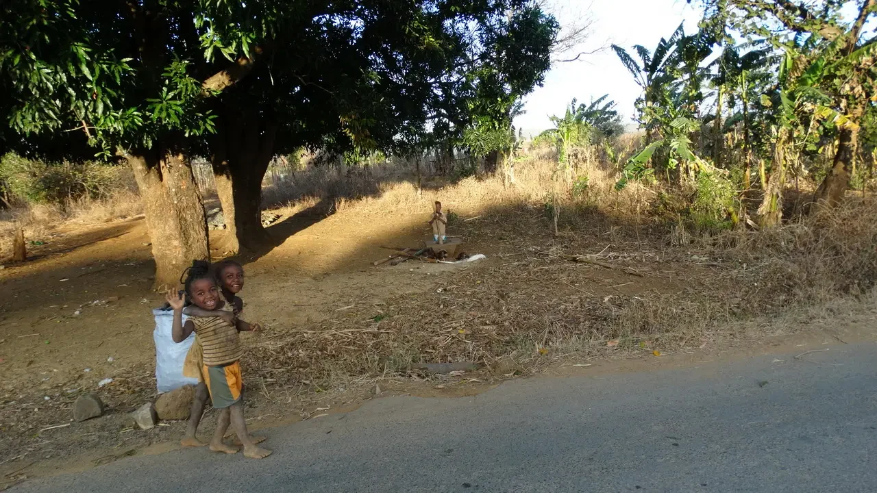 Due bambini camminano lungo la strada di campagna in Madagascar.