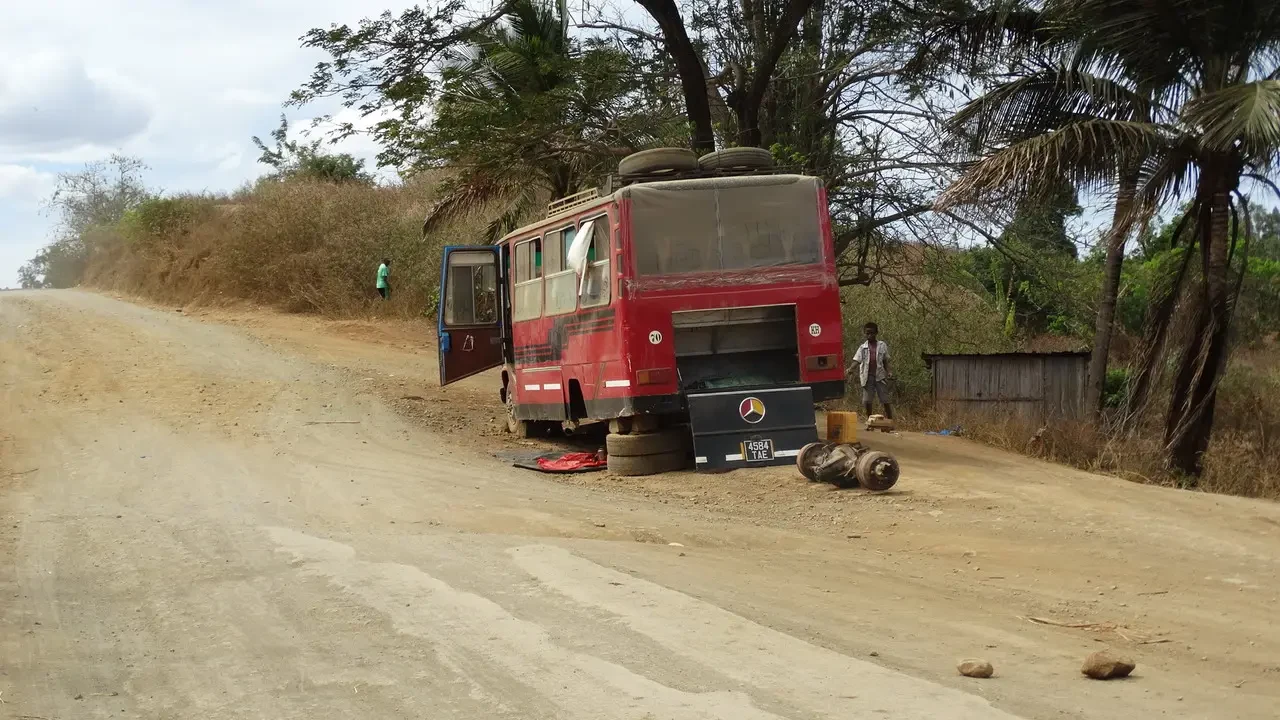 Un autobus rosso percorre una strada sterrata in Madagascar.