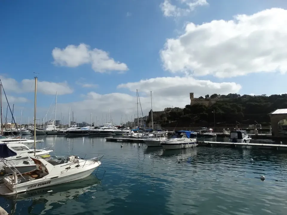 Barche ormeggiate in un porto sotto il cielo azzurro.