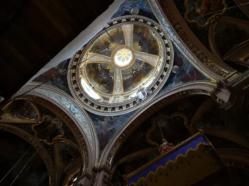 Interno di una chiesa con un soffitto a volta decorato in oro.