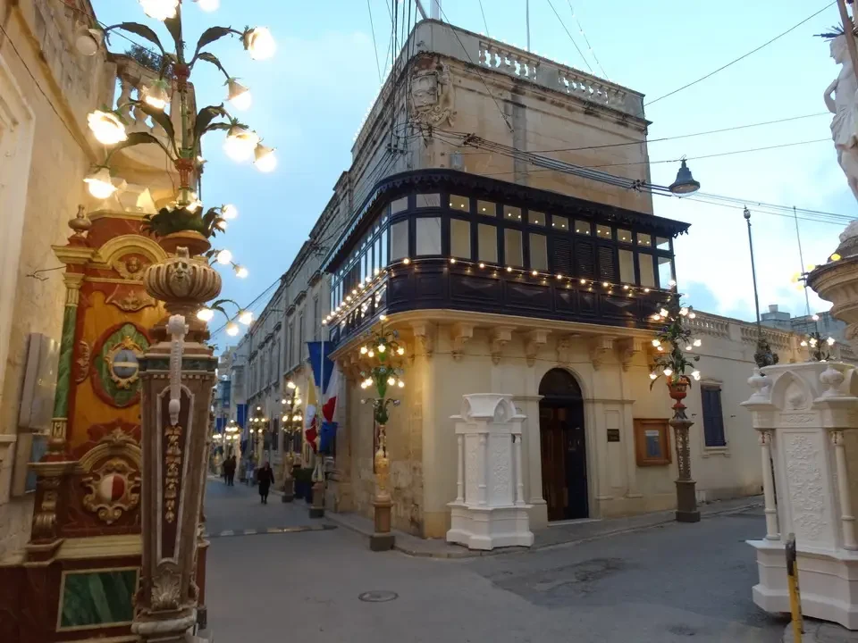 Una strada acciottolata con edifici storici in Malta al tramonto.