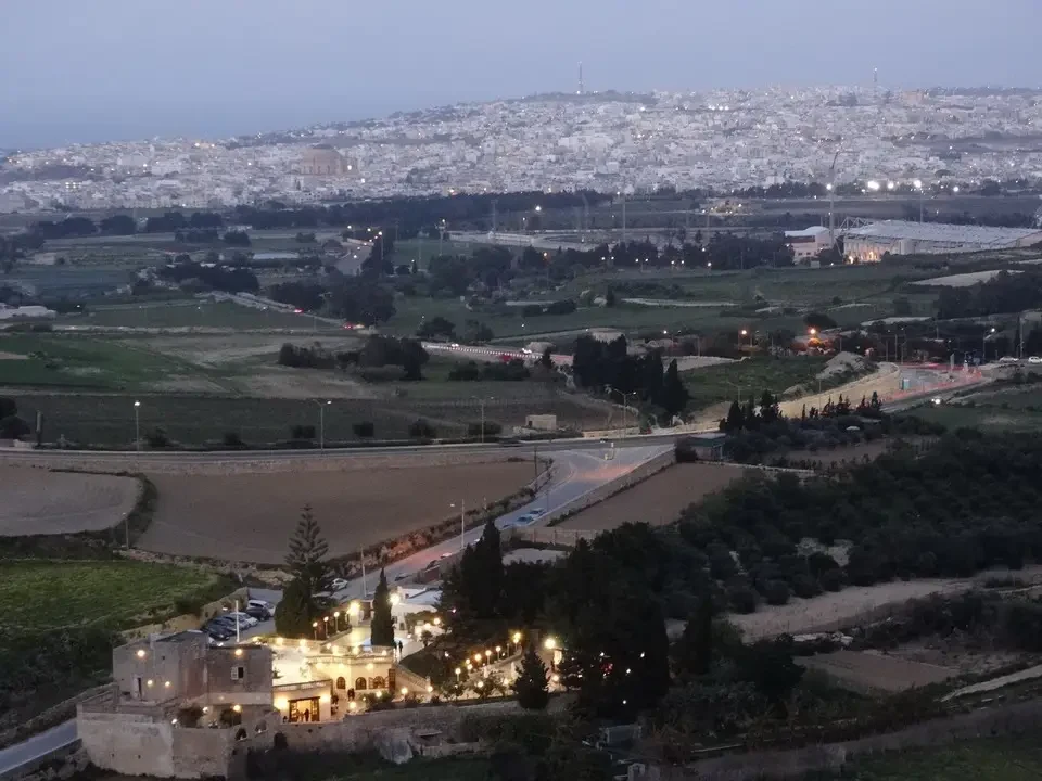 Vista panoramica di un paesaggio urbano e rurale illuminato al crepuscolo in Malta.