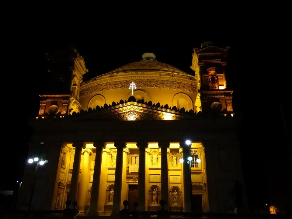 Facciata illuminata di un edificio storico maltese di notte.