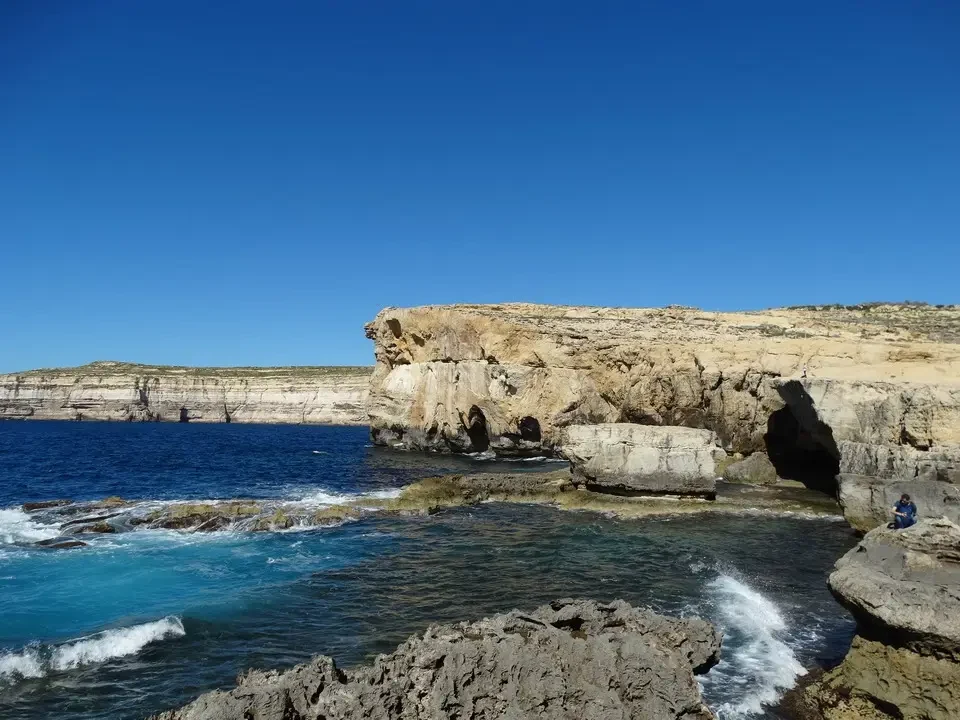 Paesaggio costiero di Gozo con formazioni rocciose e acqua cristallina.