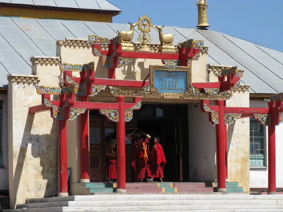 Facciata colorata di un monastero in Mongolia con persone all'ingresso.