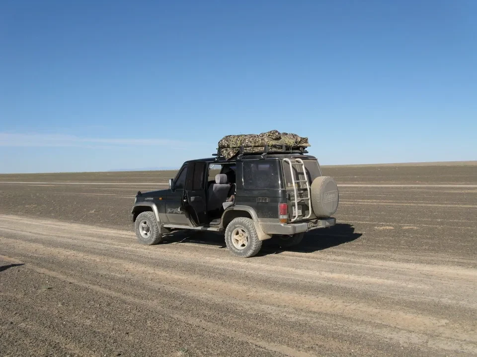 Un veicolo fuoristrada attraversa un paesaggio vasto della Mongolia.