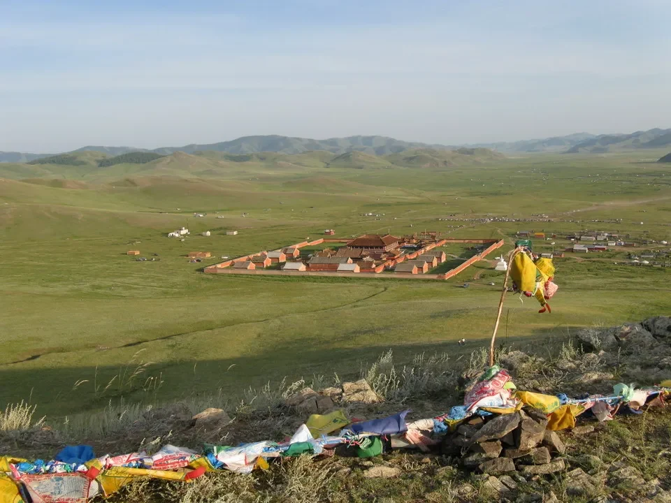 Un monastero in Mongolia si staglia su un vasto paesaggio ondulato.