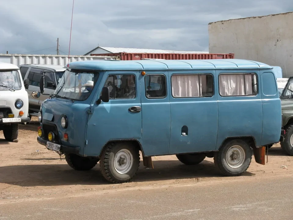 Un minivan blu parcheggiato su una strada sterrata in Mongolia.