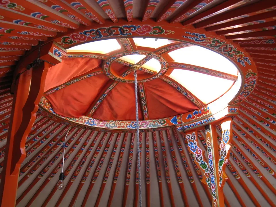 Interno colorato di una tenda mongola con un soffitto a volta decorato.