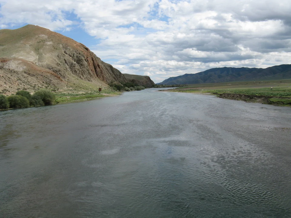 Un fiume scorre attraverso un paesaggio montano in Mongolia.