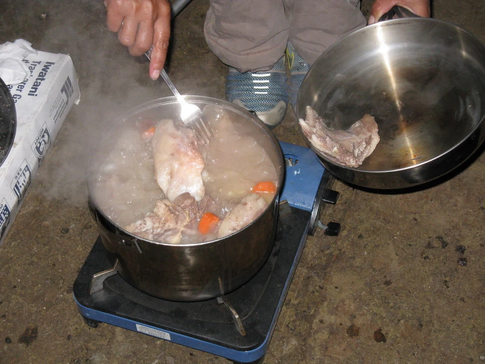 Carne in fase di cottura su un fornello da campo in Mongolia.