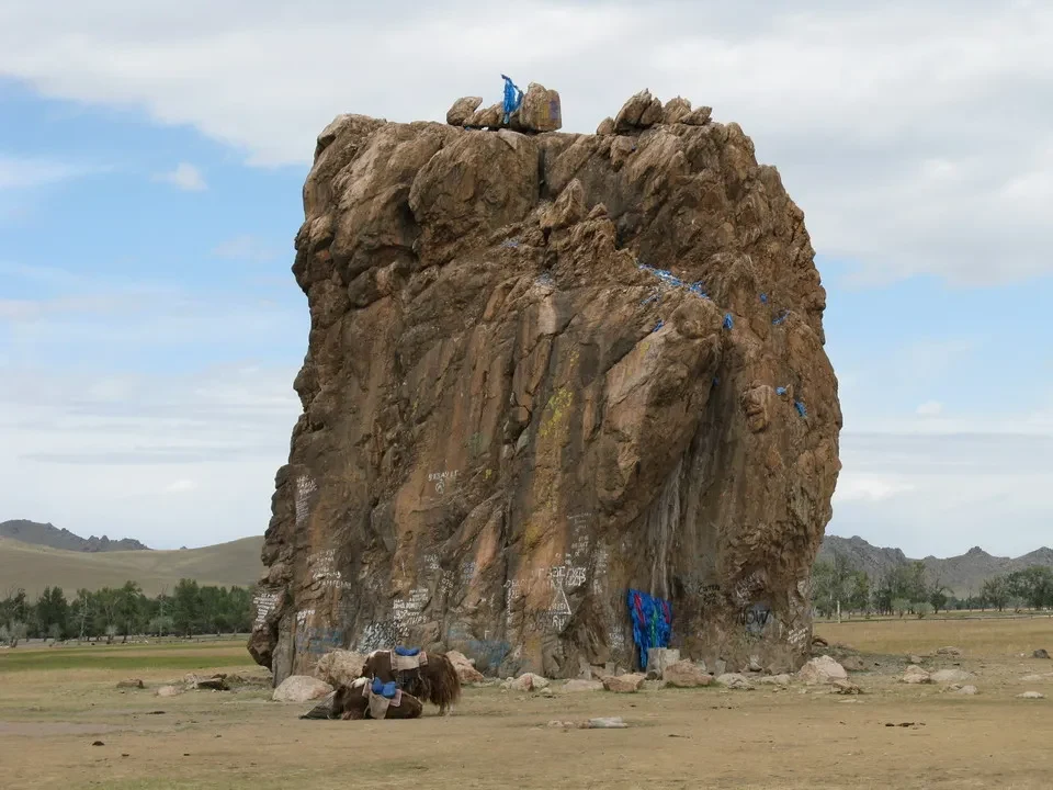 Una grande formazione rocciosa imponente si erge nel paesaggio mongolo.