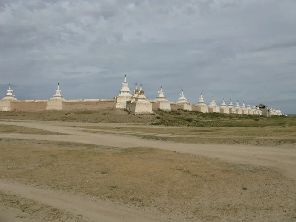 Mura di pietra con piccole cupole si estendono orizzontalmente su un paesaggio arido della Mongolia.