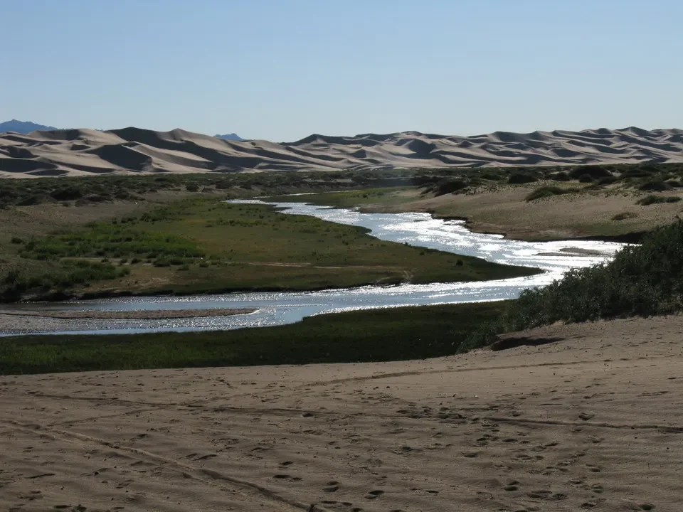 Un fiume scorre attraverso un paesaggio arido della Mongolia.