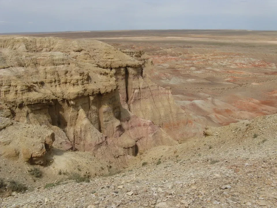 Paesaggio roccioso e arido della Mongolia con strati di colore rosso e giallo.
