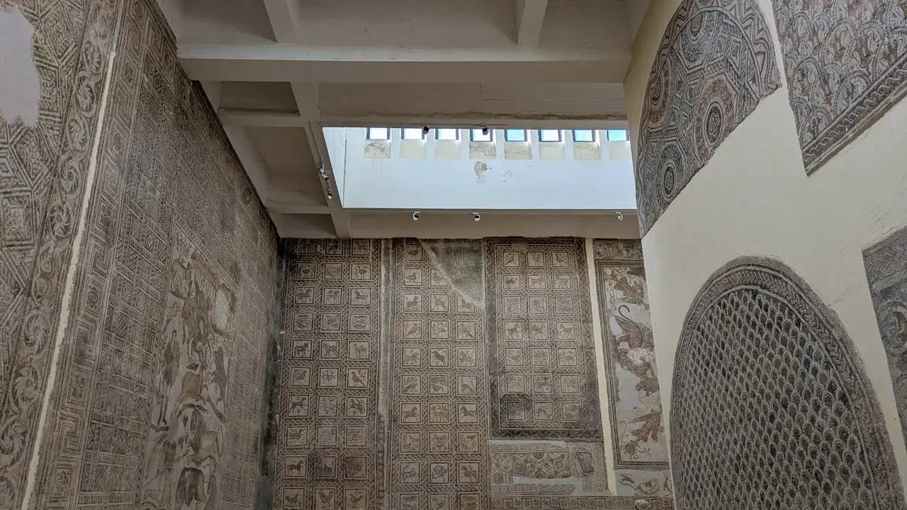 Interni decorati con elaborati motivi geometrici e pannellature murali in pietra.