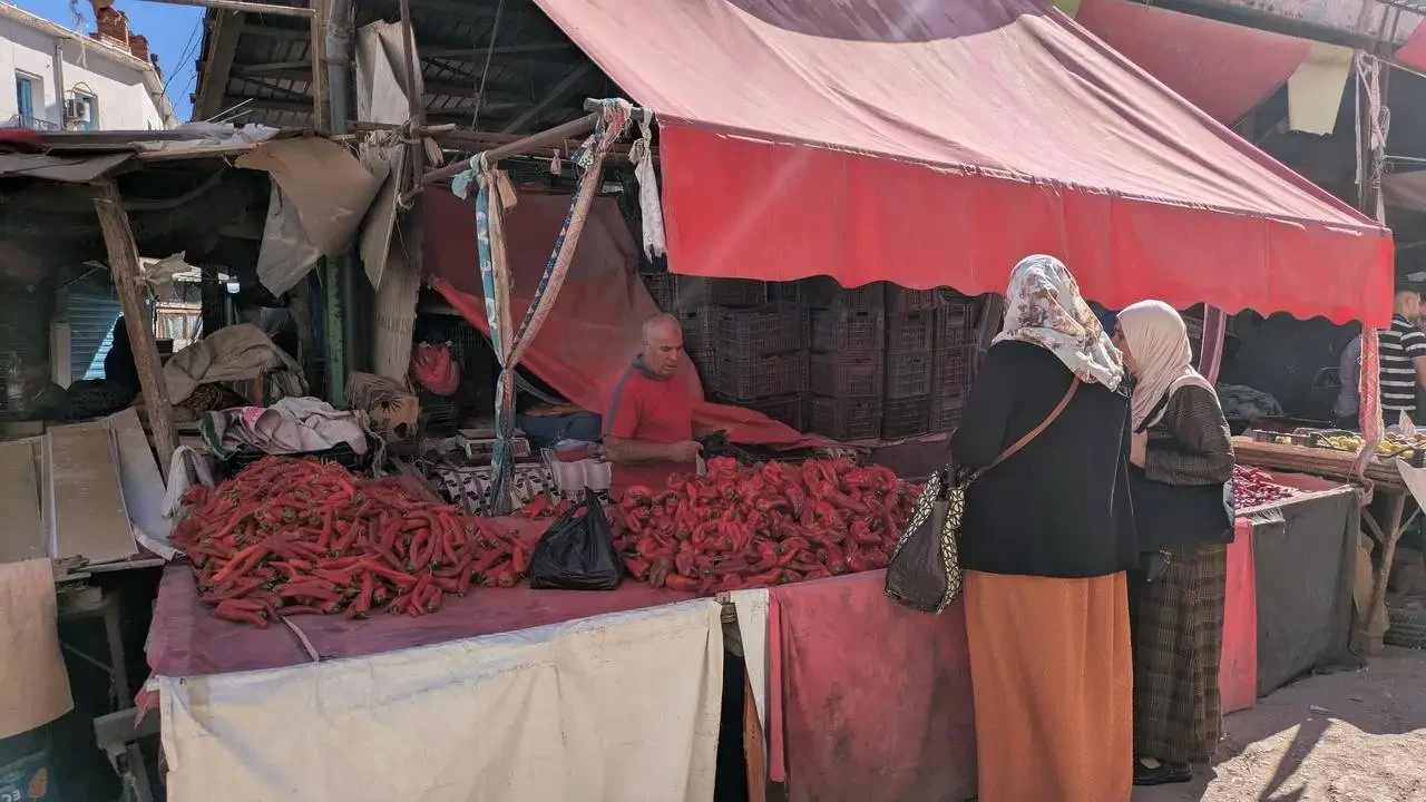 Mercato all'aperto con bancarelle di peperoncini rossi in Algeria.