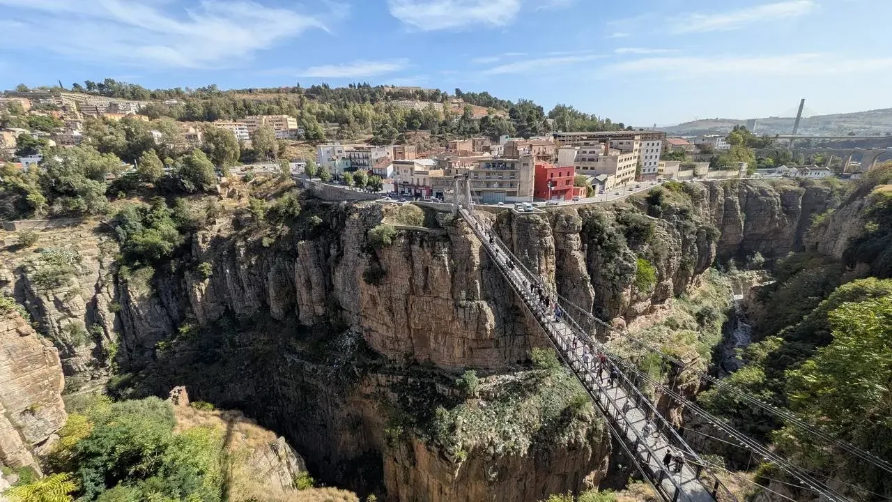 Paesaggio panoramico di scogliere rocciose con una ferrovia che attraversa il fianco della montagna.