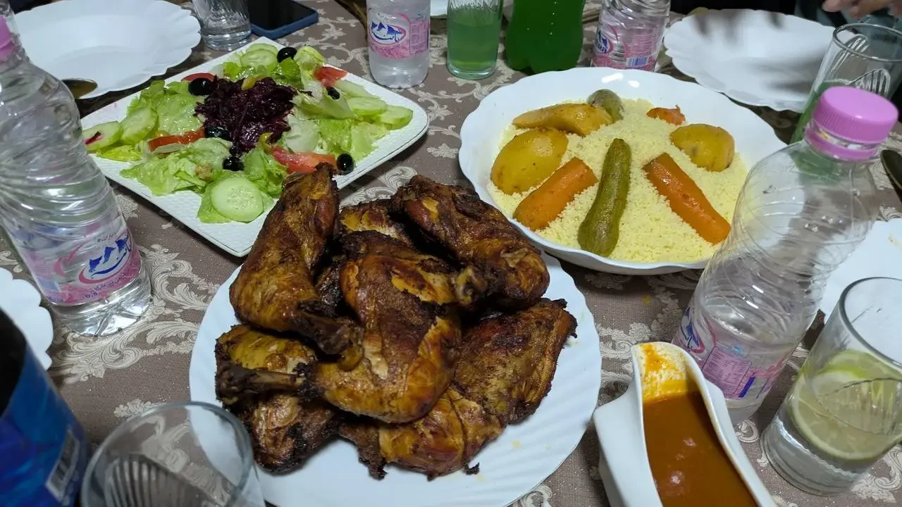 Un tavolo apparecchia un pasto di carne e contorni in Algeria.