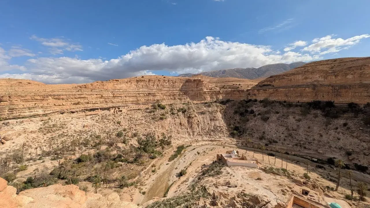 Paesaggio del canyon Ghoufi in Algeria con formazioni rocciose e terreno arido.