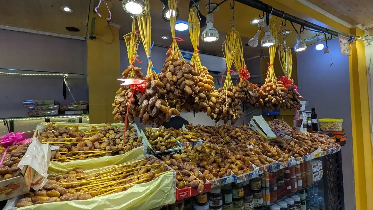 Una bancarella piena di frutta secca appesa con lanterne in un negozio in Algeria.
