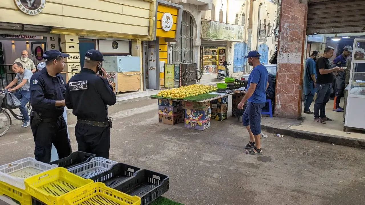 Poliziotti e venditori sono presenti in una strada commerciale in Algeria.