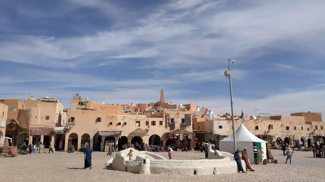 Una veduta ampia di un'antica città in mattoni di fango in Algeria sotto un cielo azzurro.