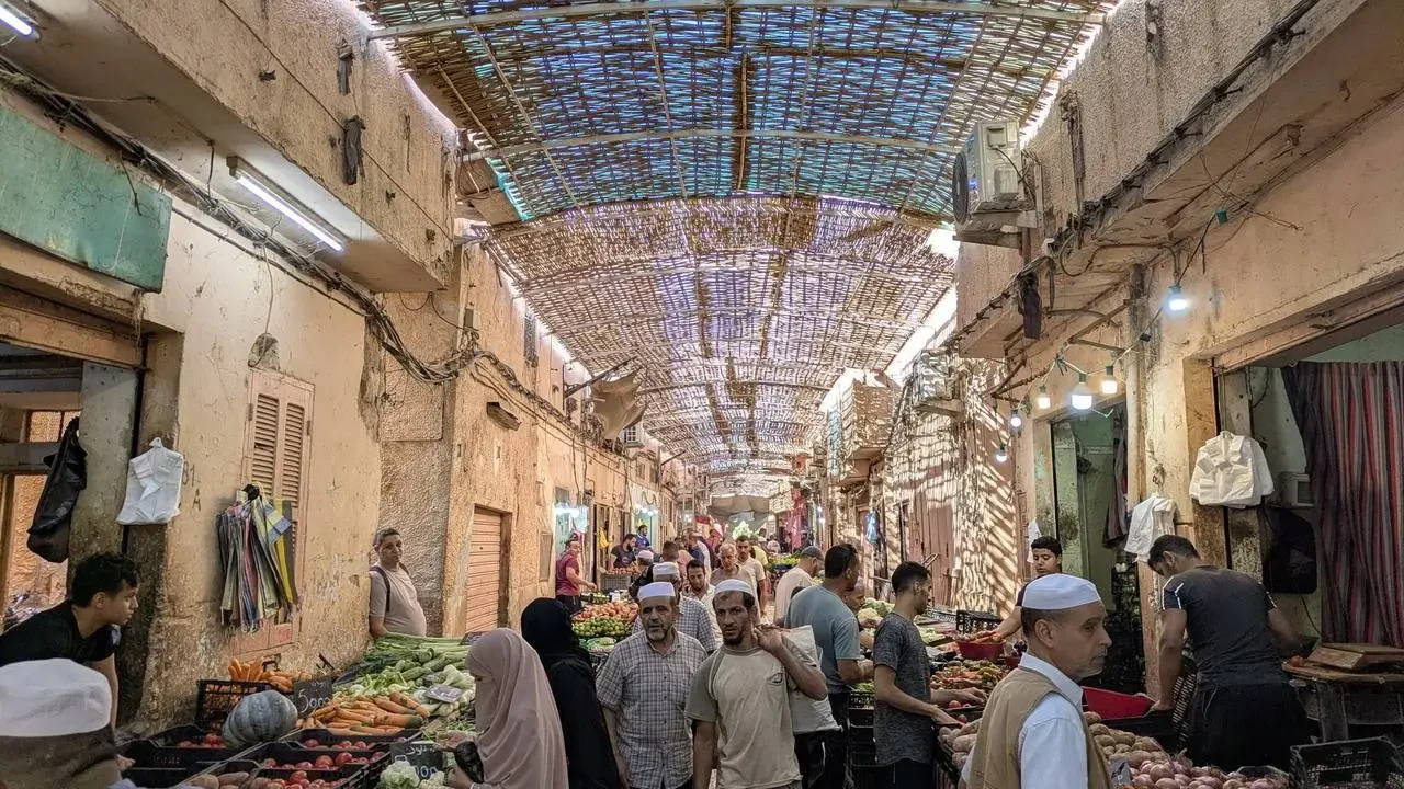 Una galleria coperta mostra un mercato tradizionale in Algeria con bancarelle di merci.