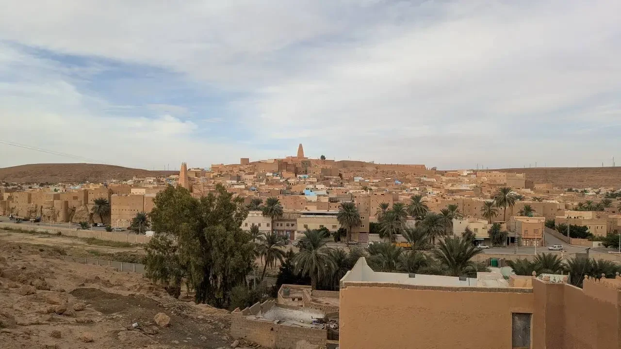 Veduta panoramica di una città arida e densamente costruita in un paesaggio secco.