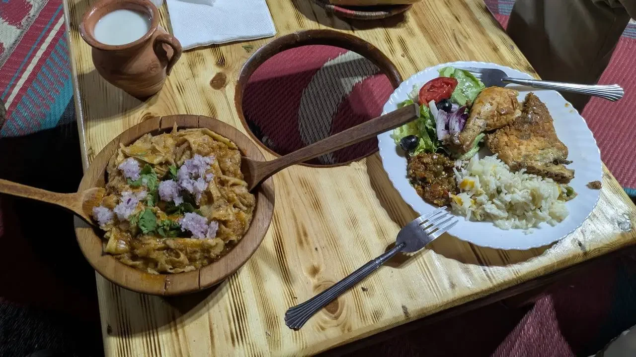 Un pasto serale in stile algerino è disposto su un tavolo di legno.