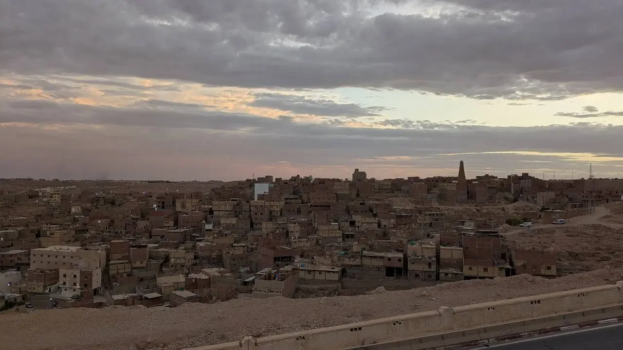 Veduta notturna degli edifici storici di Ghardaia sotto un cielo coperto.