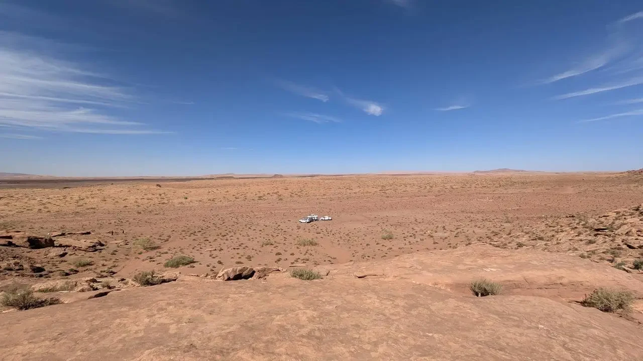 Paesaggio desertico arido in Algeria sotto un cielo azzurro.
