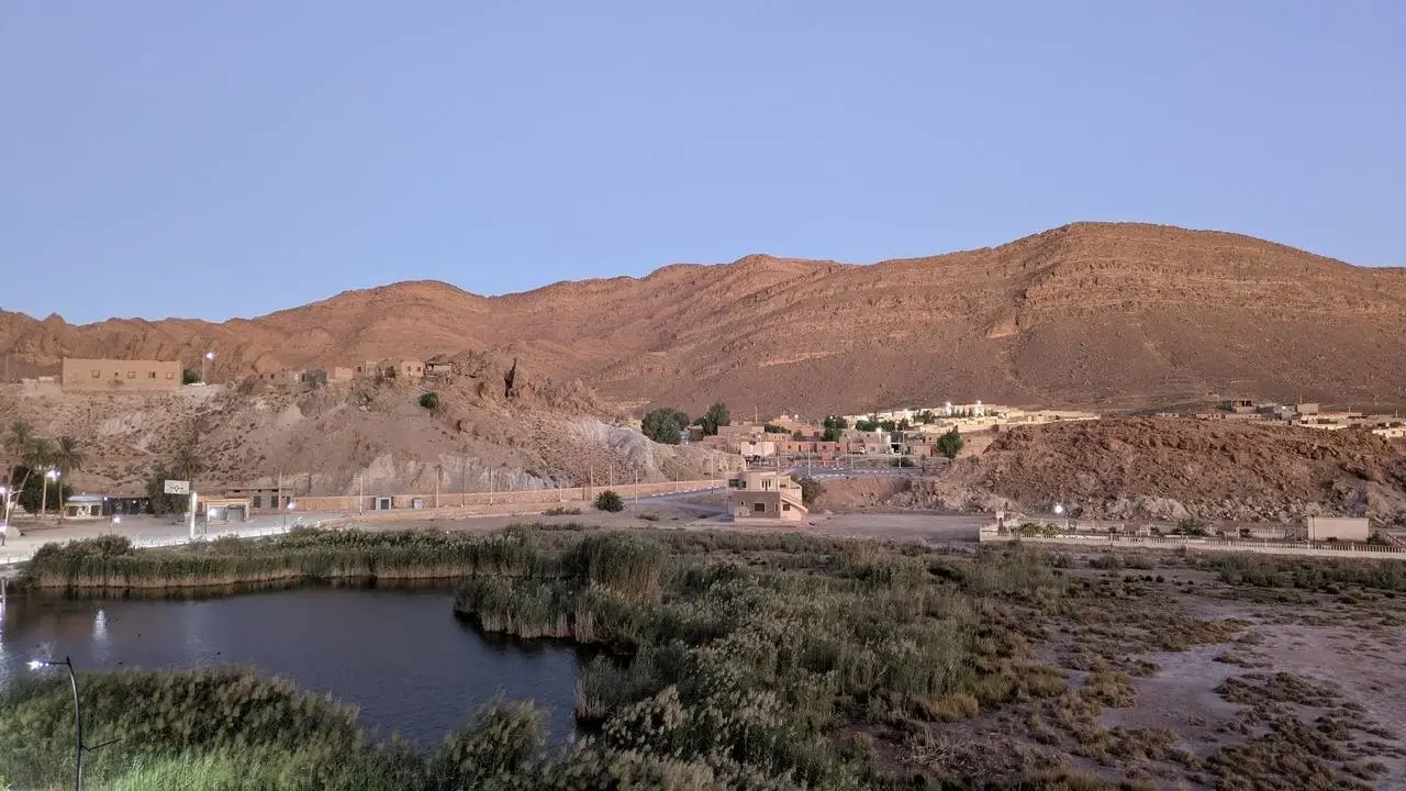 Paesaggio arido con terreno collinare e insediamenti in Algeria.