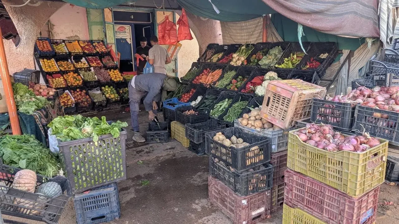 Mercato di Taghit con frutta e verdura esposte su bancali.
