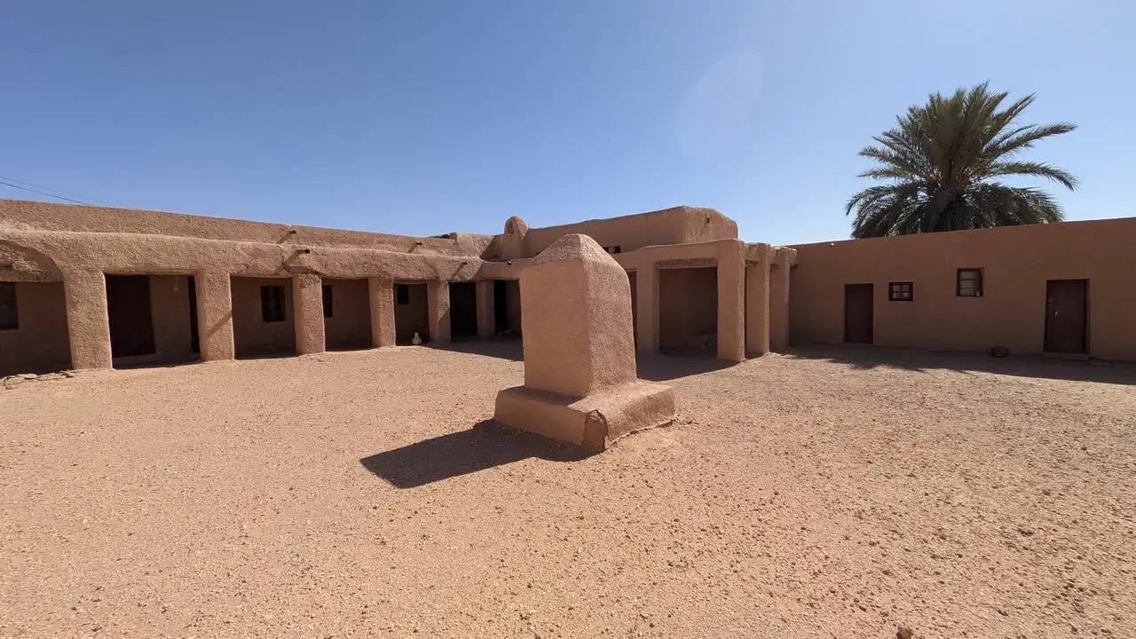 Cortile interno di un edificio in terra cotta con una struttura in pietra nel deserto algerino.