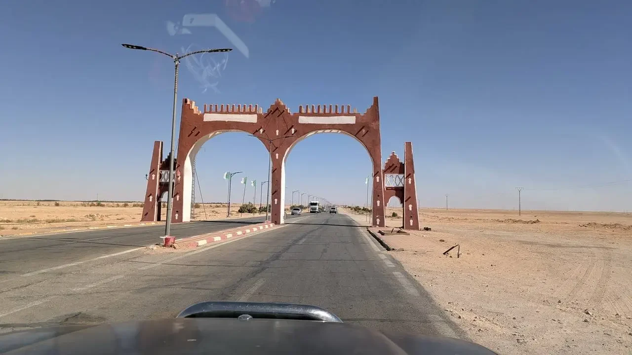 Un ponte rosso attraversa una strada deserta in Algeria.