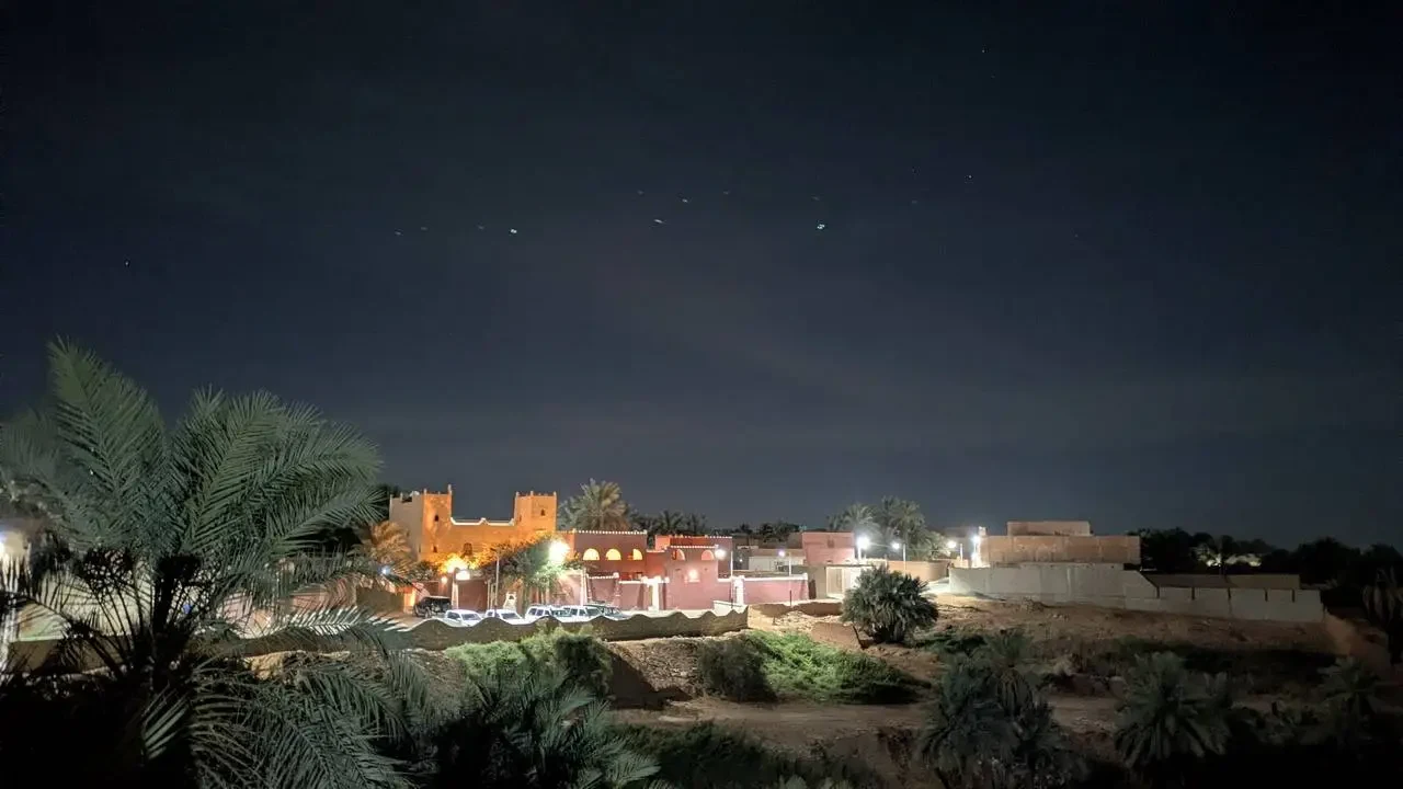 Vista notturna di un hotel in Algeria con edifici in mattoni illuminati.