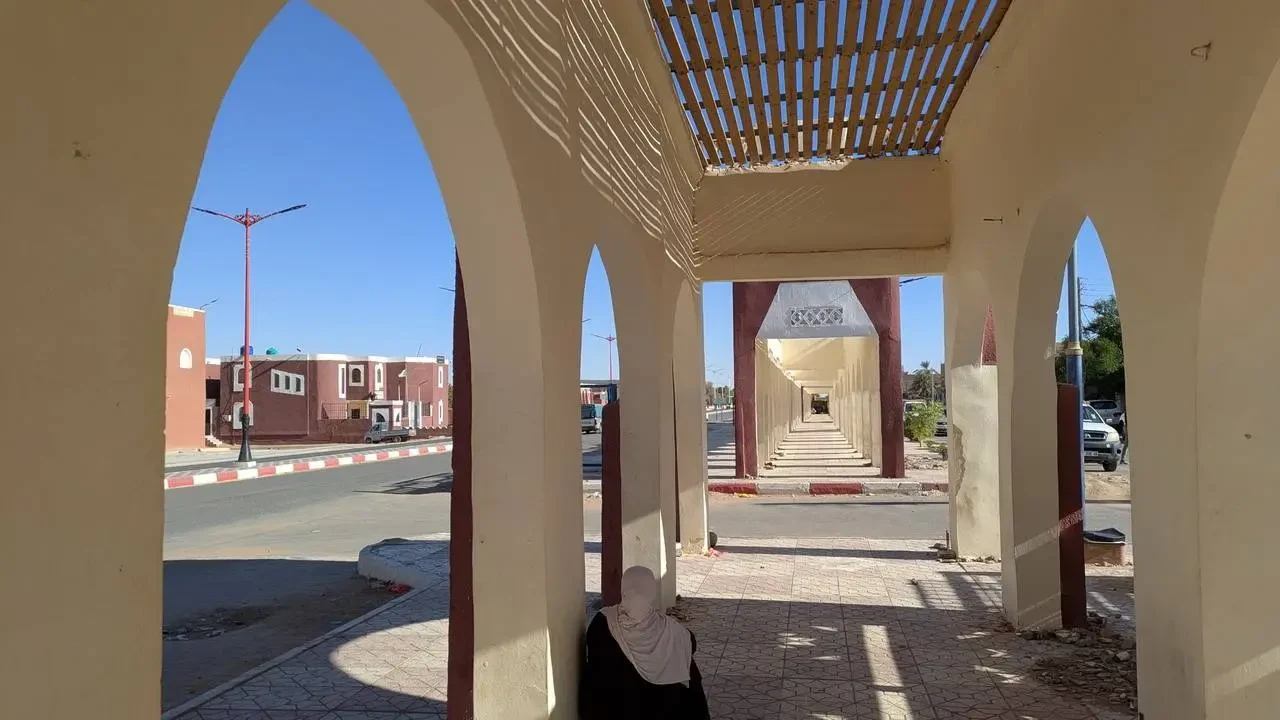 Vista di un passaggio coperto con archi in un contesto urbano algerino.